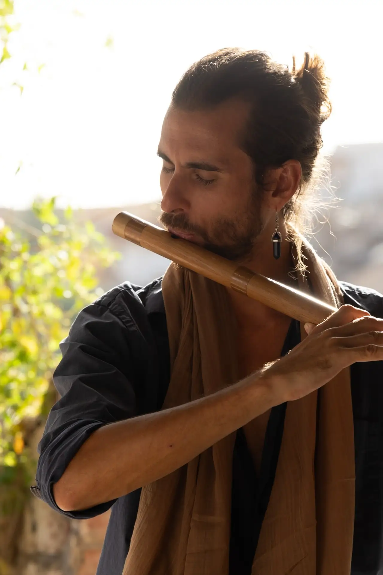 Close-up of Federico playing the bansuri in warm afternoon light