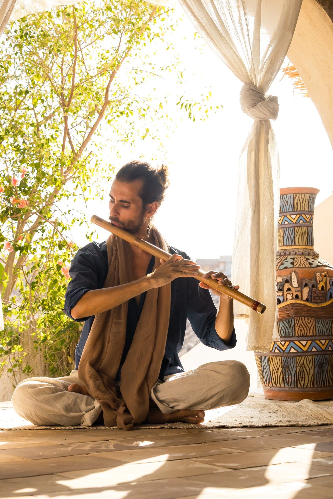 Federico playing a bamboo bansuri in warm light, a brown shawl over his shoulders