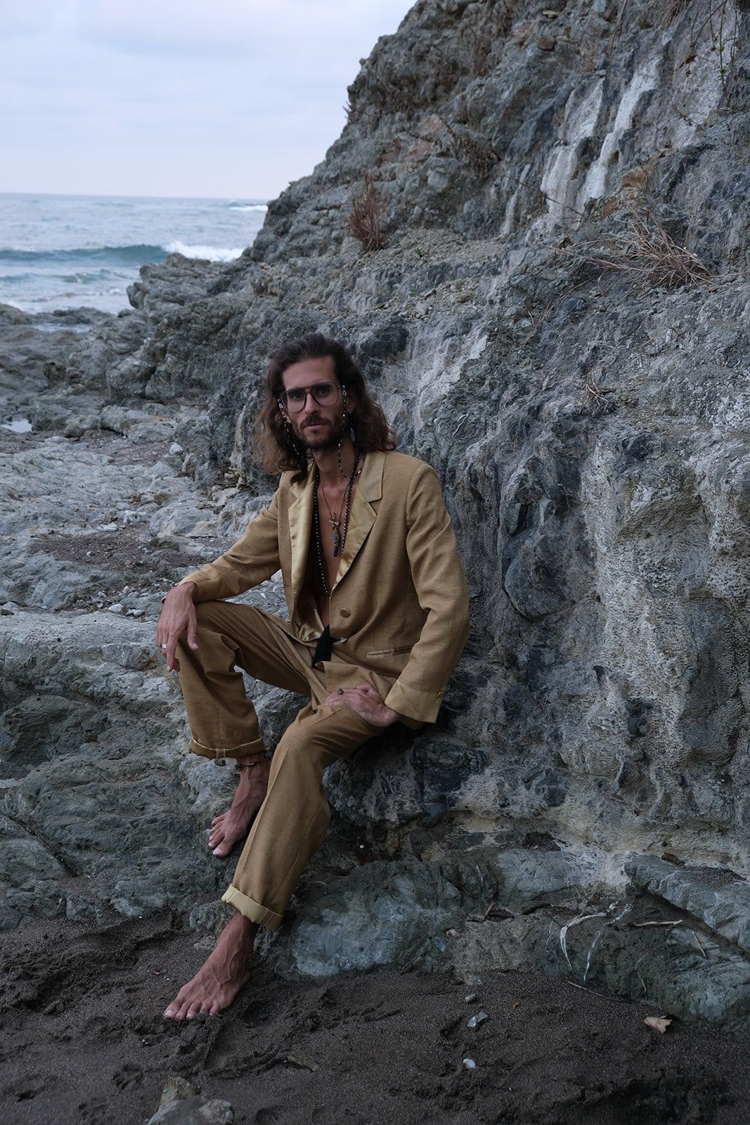 Federico sitting on coastal rocks by the sea